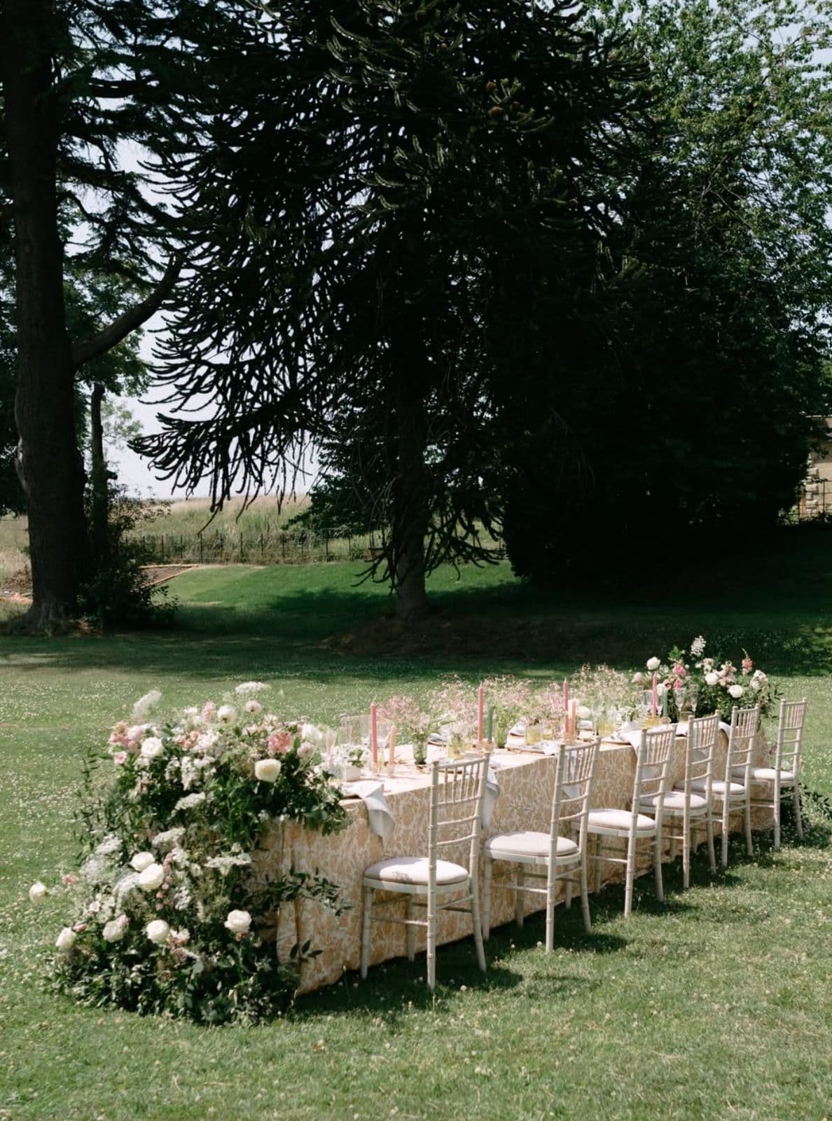 An outdoor ceremony aisle lined with flowers and chairs