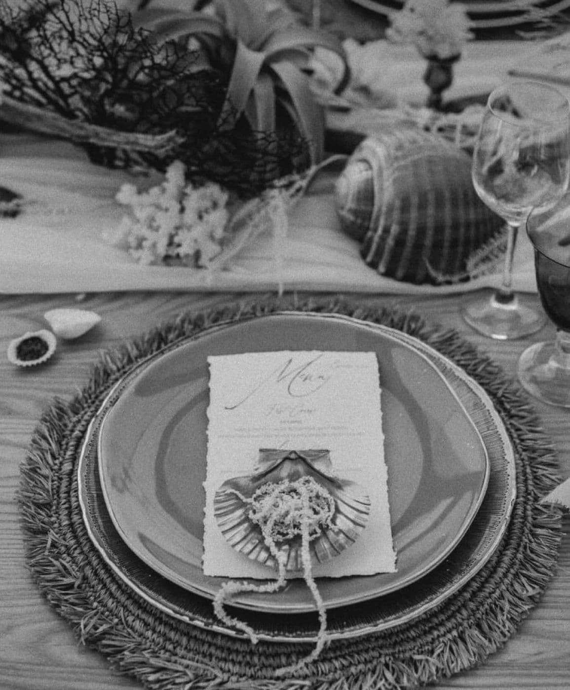 A place setting with shells, in black and white
